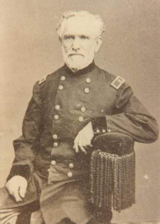 White hair and full but neatly trimmed white beard; an unwavering and uncompromising gaze